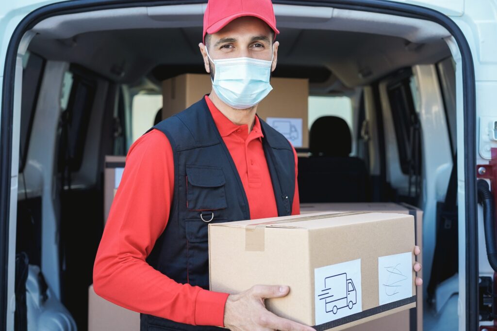 Hispanic delivery man wearing safety mask for coronavirus prevention - Focus on face