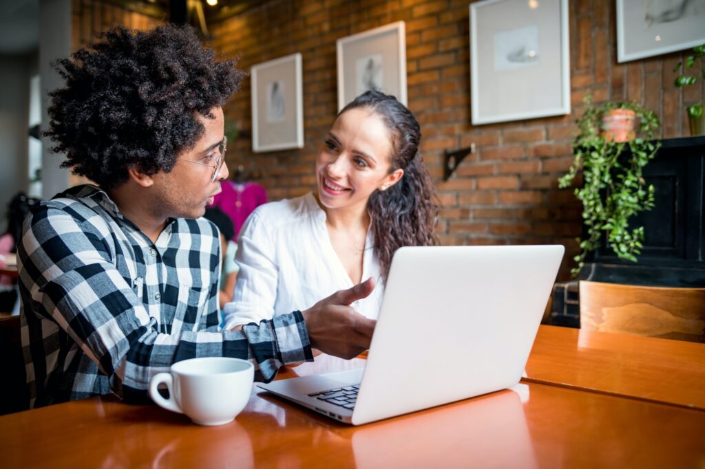 Multiethnic people meeting at cafe, advisor showing offer to client on laptop